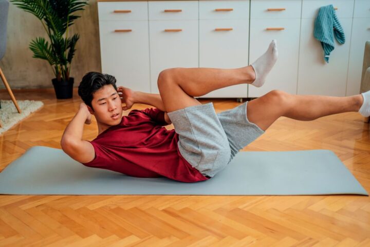 Man performs bicycle crunch at home