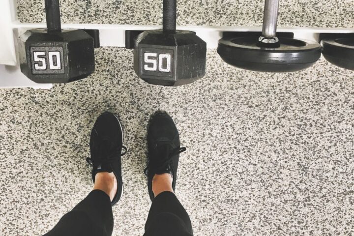 Feet standing in front of dumbbell rack