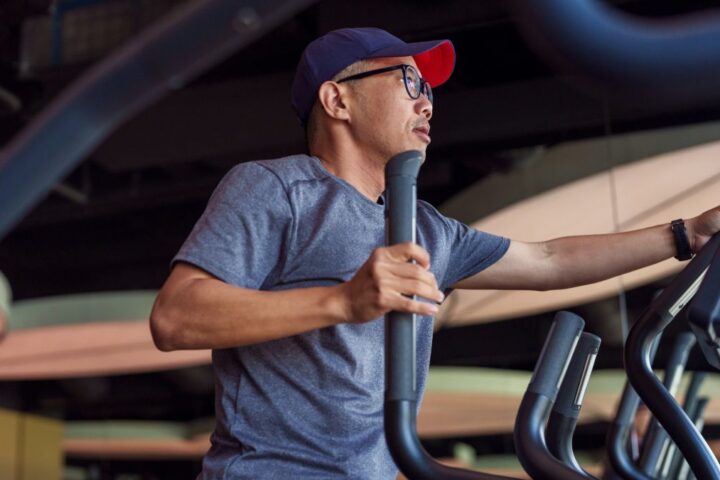 Man using cross-trainer in the gym