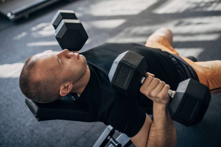 Man performing incline chest press with dumbbells