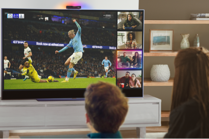 Boy and girl watching football on Sky Glass TV with Watch Together Sky Live feature on right hand side of the screen