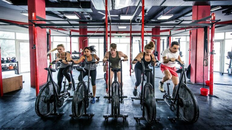 Group of people riding exercise bikes in a gym