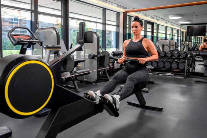 Woman using rowing machine in hotel gym