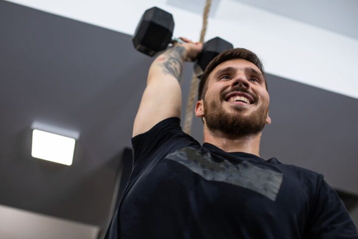 Man holding dumbbell above his head