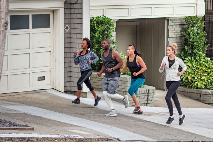 Four people running up a hill