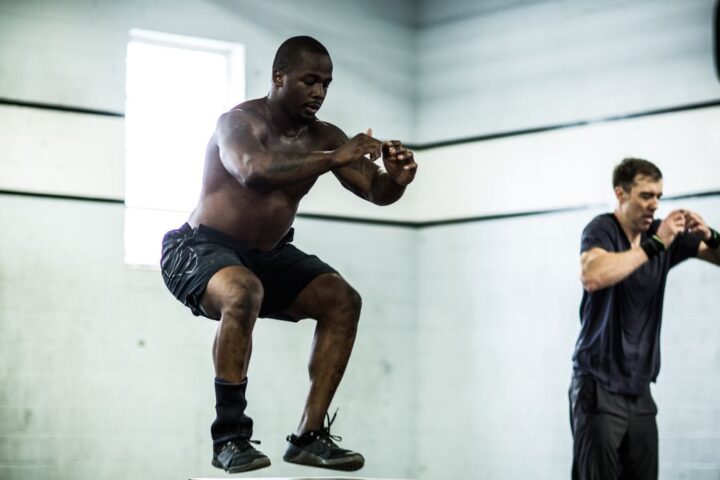 A man performing a box jump during a CrossFit workout