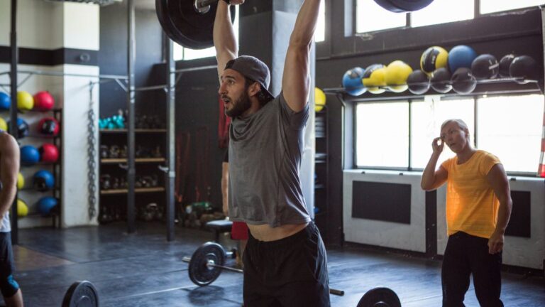 A man performing a thruster with a barbell