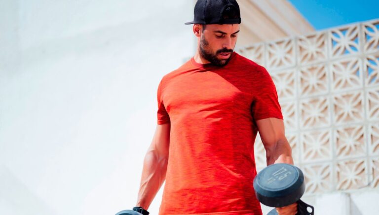 Muscular man holding heavy dumbbells